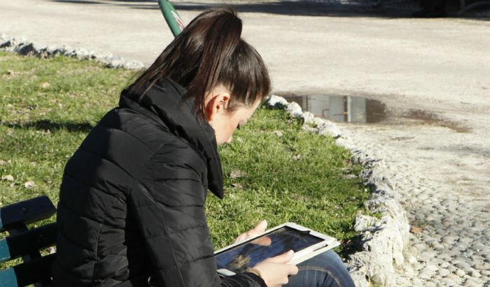 Una ragazza utilizza il proprio tablet in piazza Roma