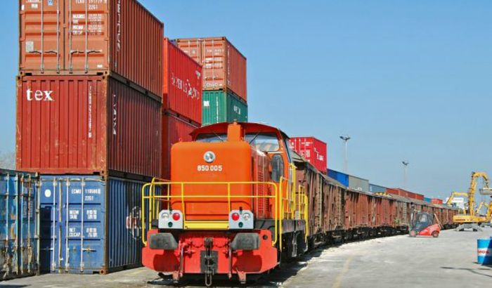 Un treno merci vicino a dei container