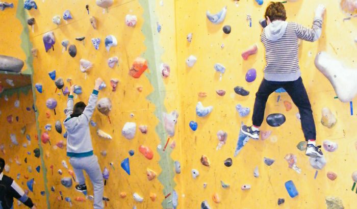Ragazzini in arrampicata su una parete artificiale