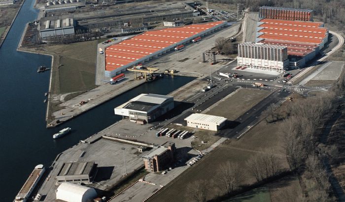 In alto a sinistra il rendering dei nuovi magazzini di Katoen Natie al porto di Cremona