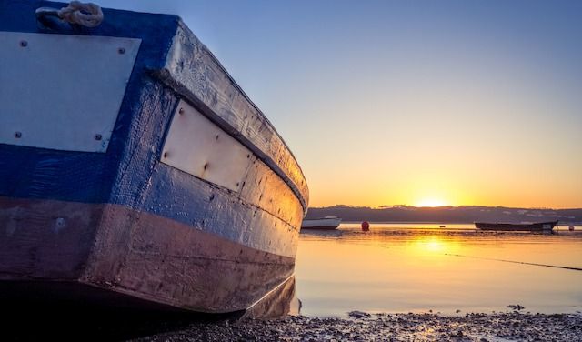A fishing boat at the river with the beautiful sunset in the background