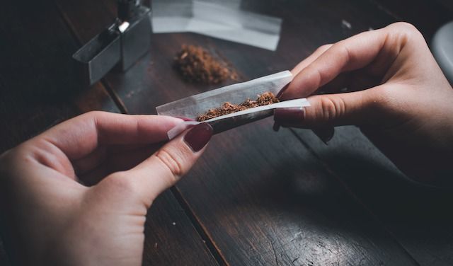 A high angle shot of a female rolling a joint
