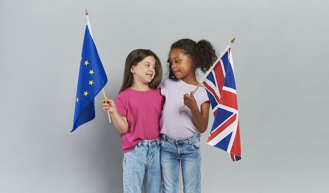 Girls embracing and holding British and European Union flags


