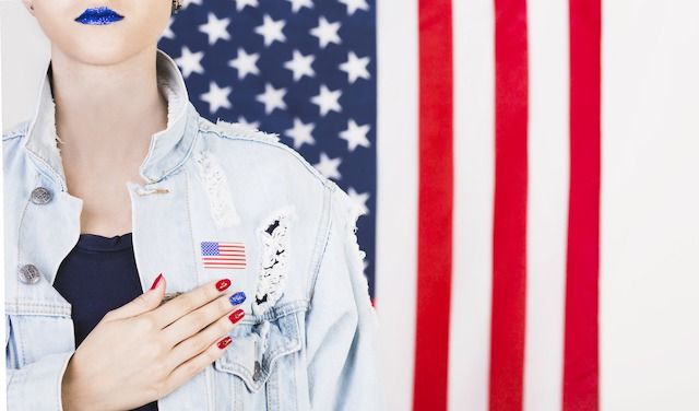 American-woman-posing-front-flag

