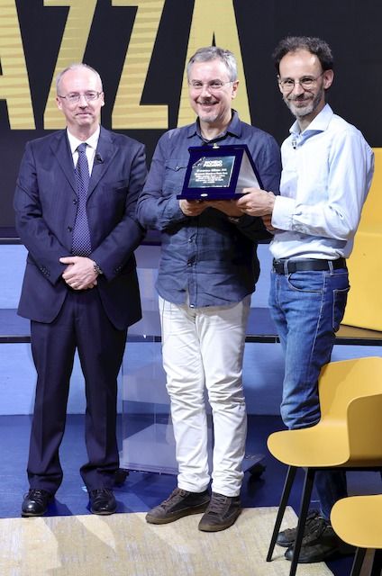 Stefano (a destra) e Marco Rozzi ritirano il Premio alla Memoria, dedicato allo zio, il professor Renato Rozzi, consegnato dal direttore di Mondo Padano, Alessandro Rossi
